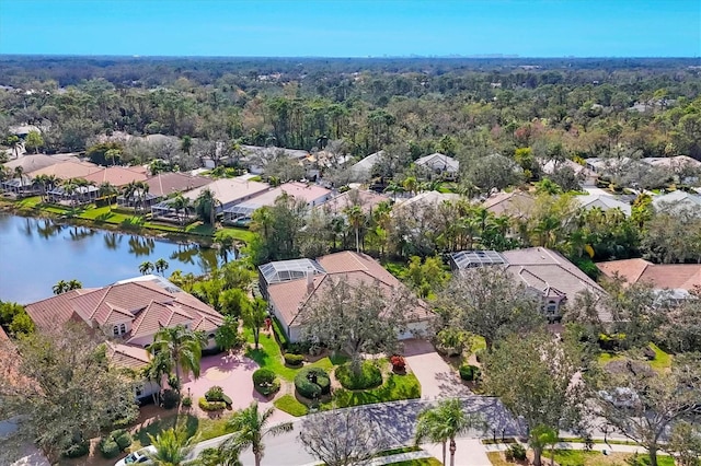 aerial view with a forest view, a water view, and a residential view