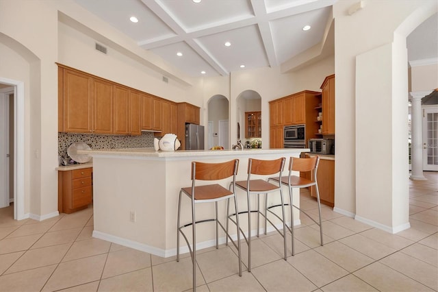 kitchen with visible vents, decorative backsplash, appliances with stainless steel finishes, a breakfast bar, and open shelves