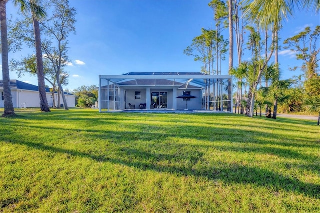 rear view of house featuring a yard and glass enclosure