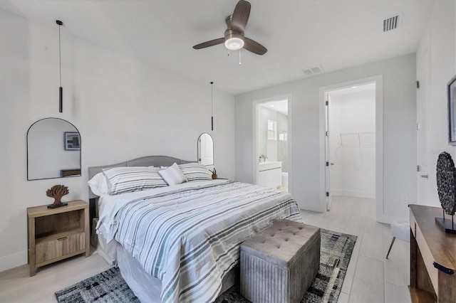 bedroom with ensuite bathroom, a spacious closet, and ceiling fan