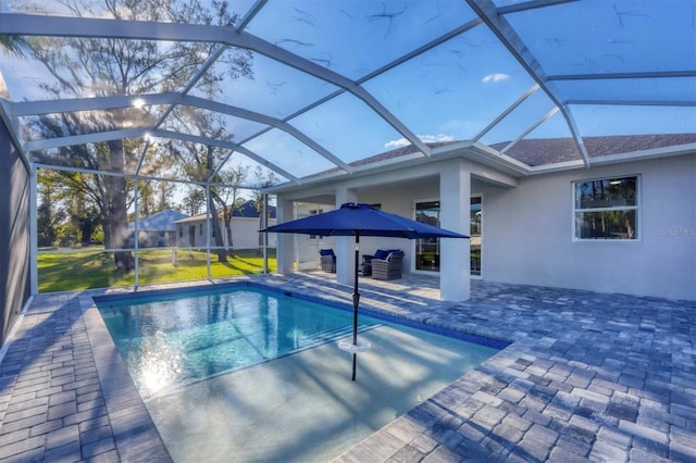 view of pool with glass enclosure and a patio area