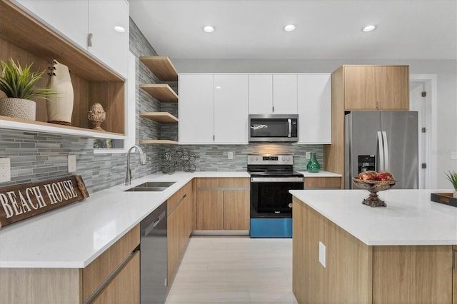 kitchen featuring stainless steel appliances, white cabinetry, sink, and tasteful backsplash