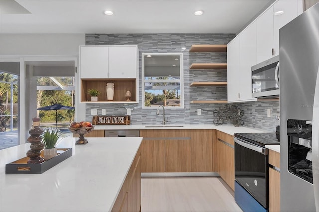 kitchen featuring tasteful backsplash, appliances with stainless steel finishes, sink, and white cabinets