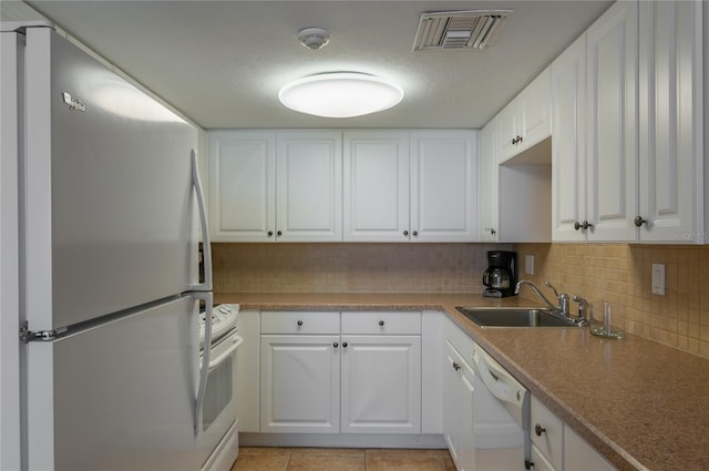 kitchen featuring sink, white appliances, light tile patterned floors, backsplash, and white cabinets