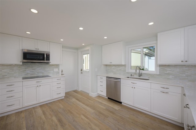 kitchen with appliances with stainless steel finishes, sink, and white cabinets