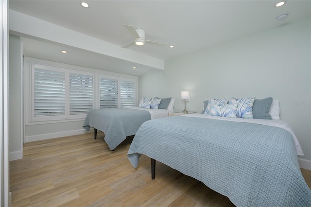 bedroom with beamed ceiling, ceiling fan, and light wood-type flooring