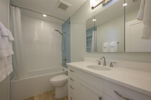 full bathroom featuring vanity, hardwood / wood-style floors, shower / bath combination with curtain, and toilet