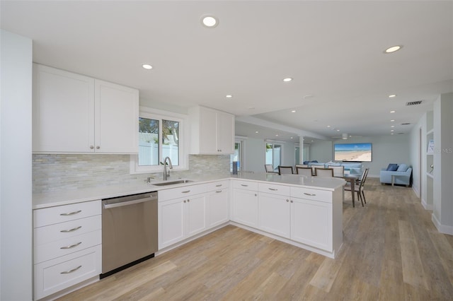 kitchen with sink, dishwasher, white cabinetry, kitchen peninsula, and light wood-type flooring