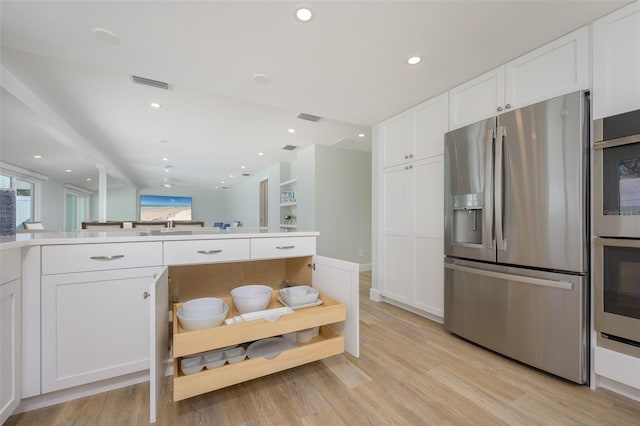 kitchen featuring stainless steel appliances, white cabinetry, plenty of natural light, and light hardwood / wood-style flooring