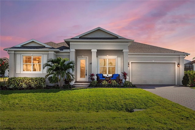 view of front of property with a yard and a garage