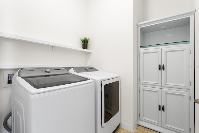 washroom featuring cabinets and separate washer and dryer