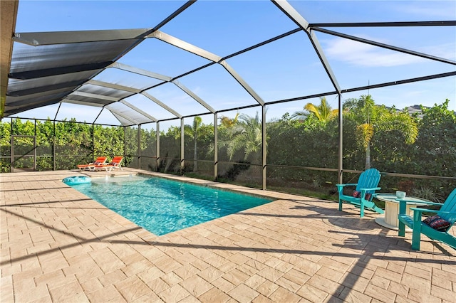 view of pool with glass enclosure and a patio area