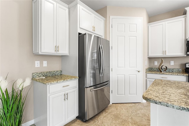 kitchen featuring appliances with stainless steel finishes, white cabinetry, and light stone counters