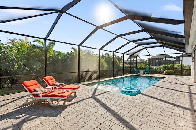 view of swimming pool featuring a patio area and a lanai