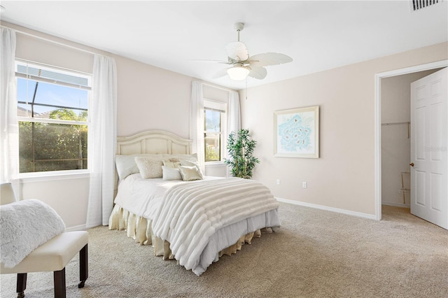 carpeted bedroom with multiple windows and ceiling fan