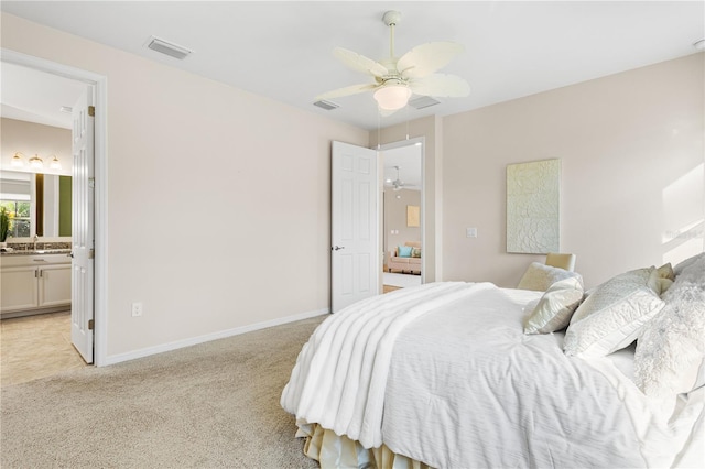 bedroom featuring ensuite bathroom, ceiling fan, and light colored carpet