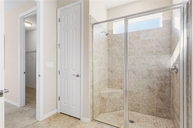 bathroom with a shower with shower door and tile patterned floors