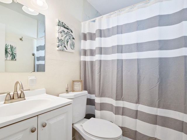 bathroom featuring a shower with curtain, vanity, and toilet