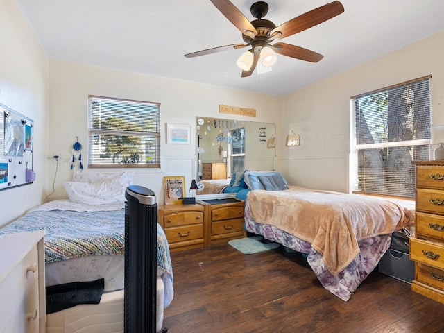 bedroom featuring multiple windows, dark hardwood / wood-style floors, and ceiling fan