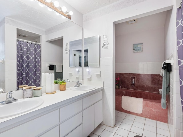 bathroom featuring vanity, tile patterned flooring, tile walls, and a textured ceiling