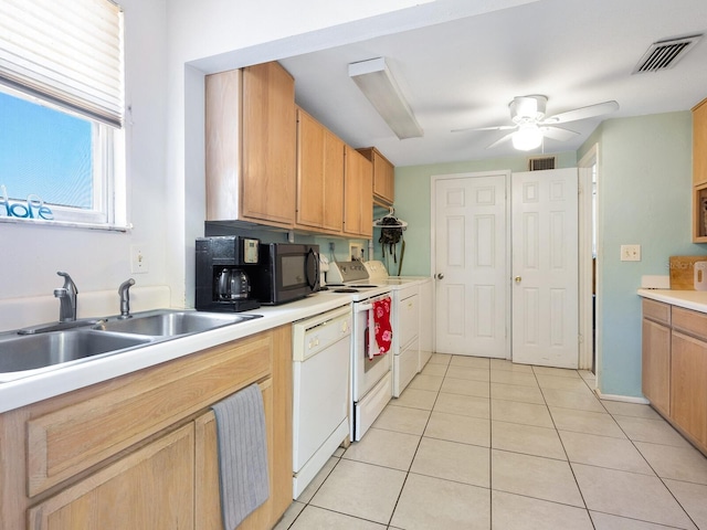 kitchen featuring light tile patterned flooring, sink, ceiling fan, white appliances, and washing machine and dryer