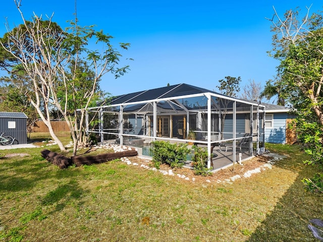 rear view of house with a lanai and a lawn