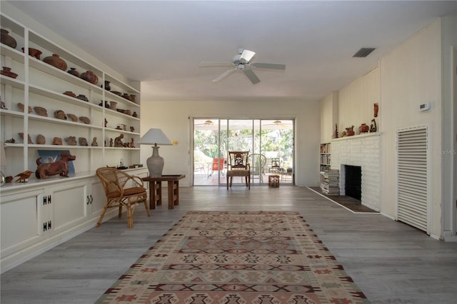 1555 Flower Dr, Sarasota, FL 34239 - sitting room featuring light hardwood / wood-style floors, ceiling fan, and a fireplace