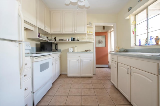 1555 Flower Dr, Sarasota, FL 34239 - kitchen featuring ceiling fan, light tile patterned floors, white appliances, and white cabinets