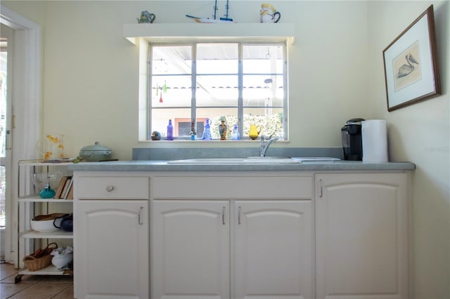 1555 Flower Dr, Sarasota, FL 34239 - kitchen with sink, white cabinets, and tile patterned floors
