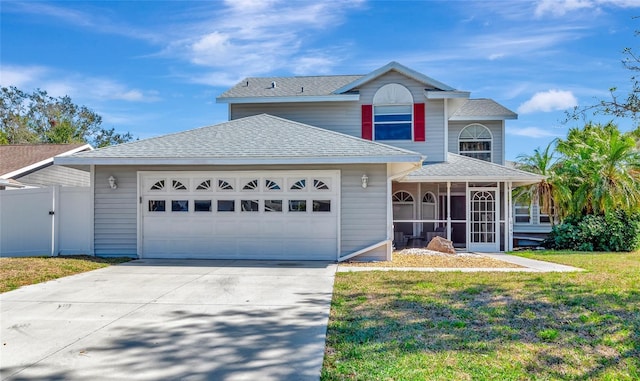 front of property with a garage, a sunroom, and a front yard