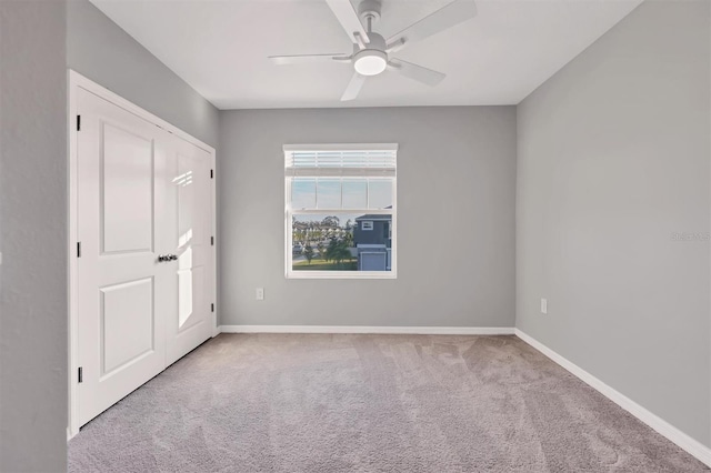 carpeted empty room featuring ceiling fan