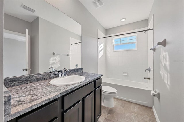 full bathroom featuring vanity, tiled shower / bath, and toilet