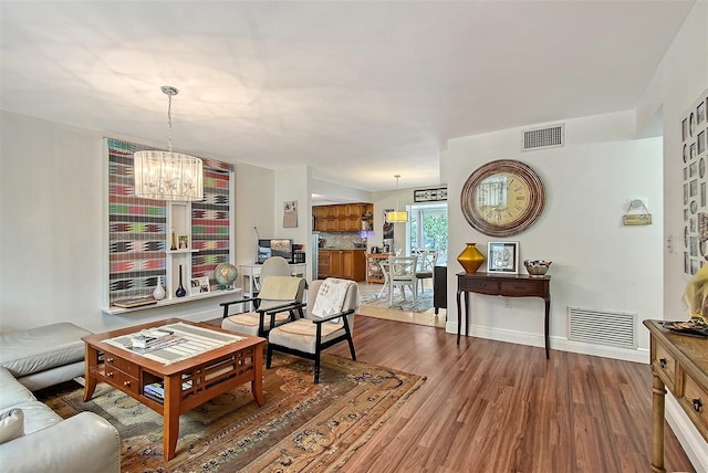 living room featuring an inviting chandelier and hardwood / wood-style floors