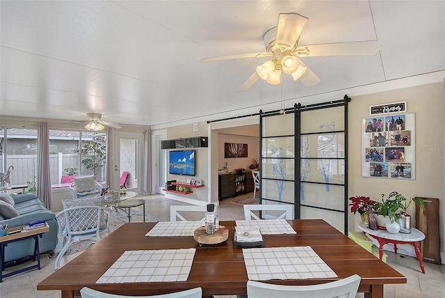 dining space with light tile patterned flooring, a barn door, and ceiling fan