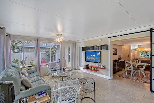 tiled living room with a barn door and ceiling fan