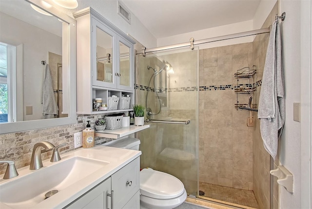 bathroom featuring tasteful backsplash, toilet, vanity, and walk in shower