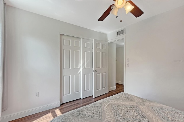 bedroom featuring ceiling fan, dark hardwood / wood-style flooring, and a closet