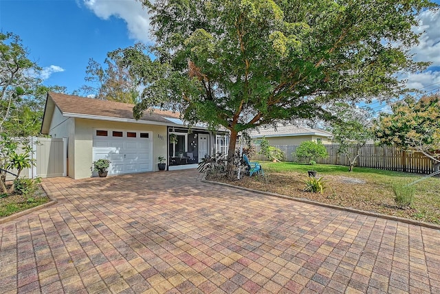 ranch-style home with a garage and a front lawn