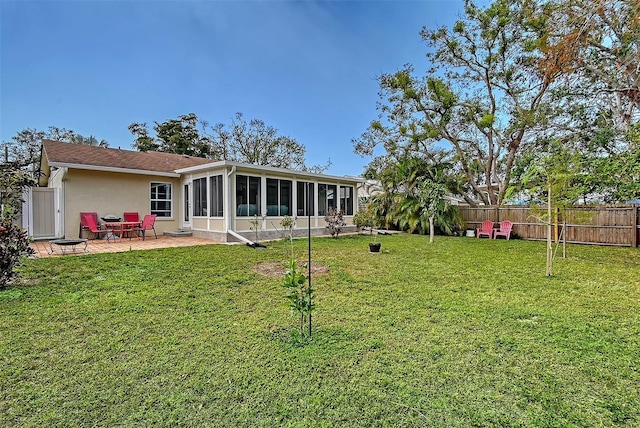 back of house with a sunroom, a patio area, and a lawn