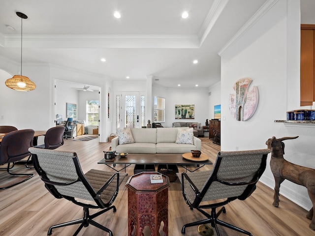 living room featuring ornamental molding, decorative columns, and light hardwood / wood-style flooring