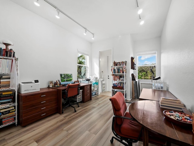 office area with track lighting, light hardwood / wood-style floors, and a healthy amount of sunlight