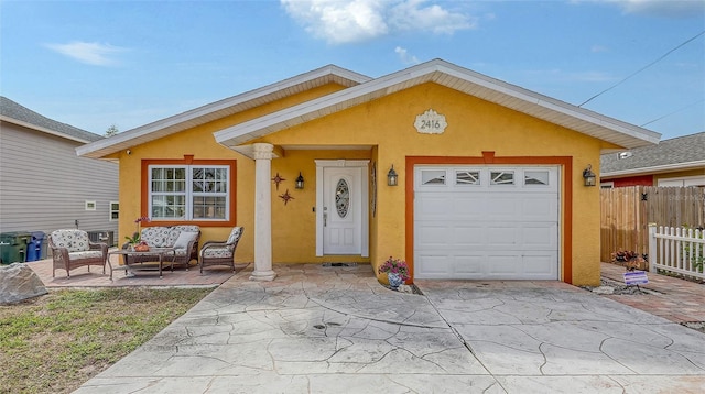 view of front facade with a garage, concrete driveway, fence, outdoor lounge area, and stucco siding