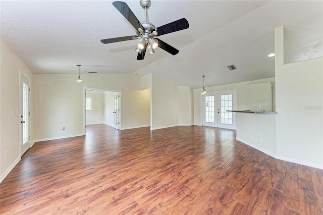 unfurnished living room featuring lofted ceiling, hardwood / wood-style floors, a textured ceiling, and ceiling fan