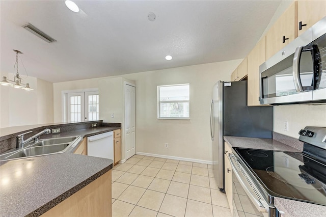 kitchen featuring appliances with stainless steel finishes, sink, hanging light fixtures, kitchen peninsula, and light brown cabinets