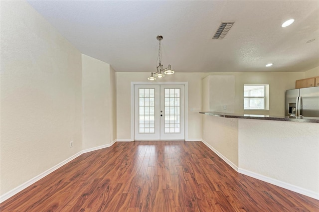 interior space with plenty of natural light, dark wood-type flooring, pendant lighting, and french doors