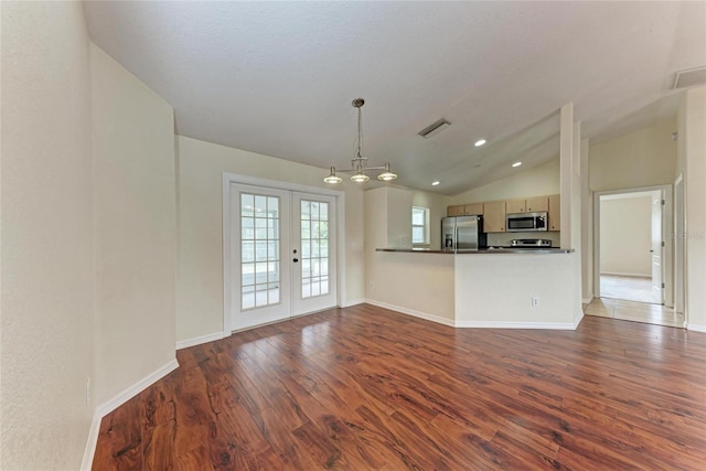 unfurnished living room with vaulted ceiling, dark hardwood / wood-style floors, and french doors