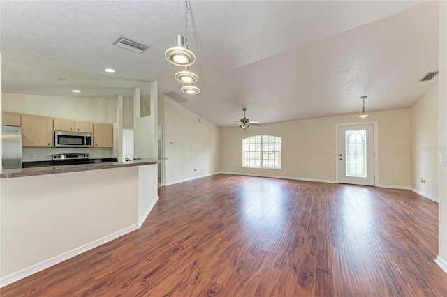 unfurnished living room with pendant lighting, lofted ceiling, dark hardwood / wood-style flooring, and light brown cabinetry