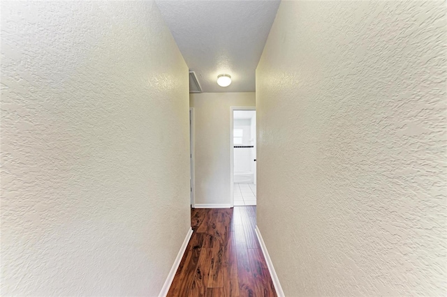 hall featuring hardwood / wood-style flooring and a textured ceiling