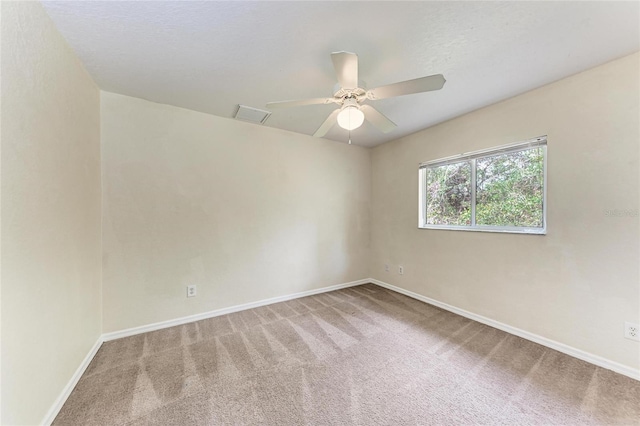 spare room with ceiling fan and carpet