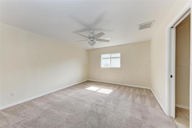 unfurnished room with light colored carpet, a textured ceiling, and ceiling fan